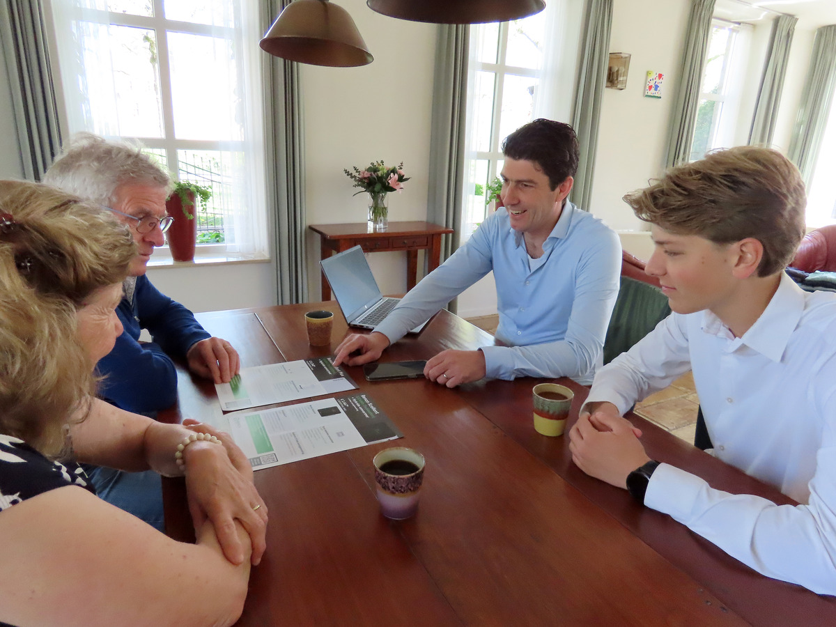 Adviesgesprek over een thuisbatterij aan de keukentafel bij klanten thuis